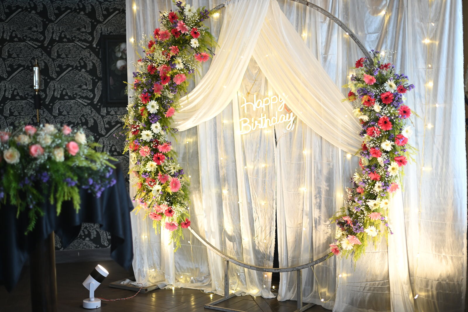 Floral circular arch with sheer drapes and warm fairy lights