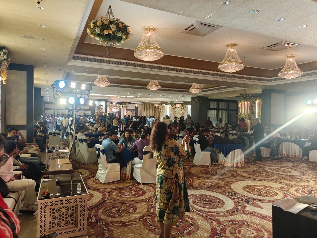 A full house of guests at the corporate gala beneath crystal chandeliers