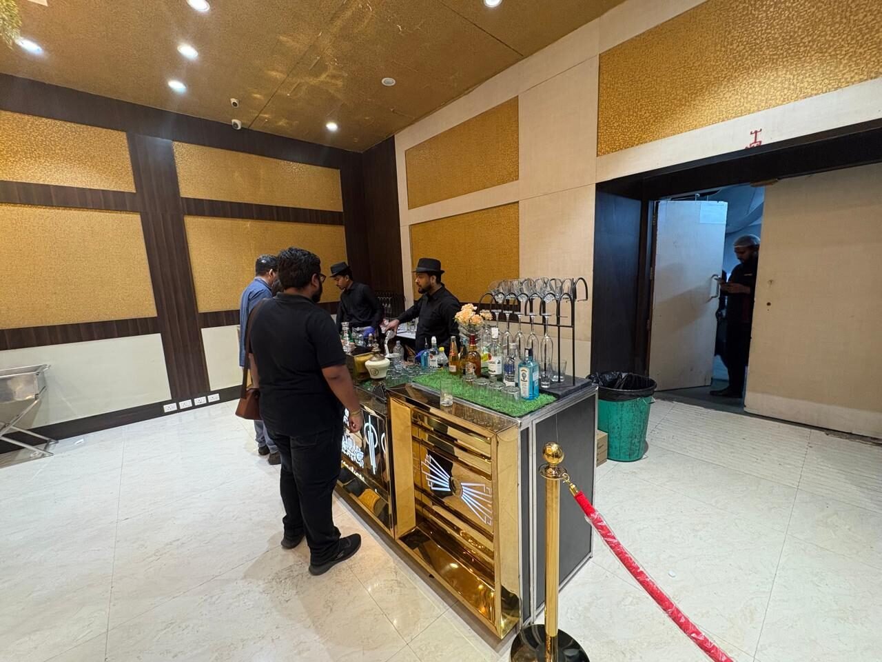 Stocked bar counter with staff serving guests