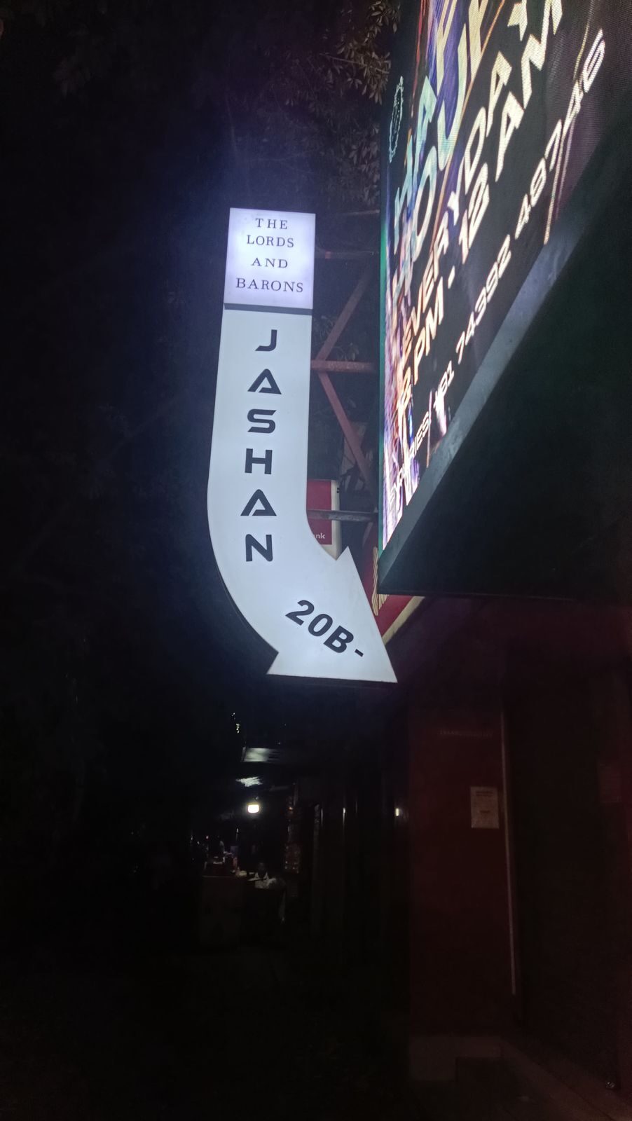 Glowing arrow signage marking the entrance to the venue at night